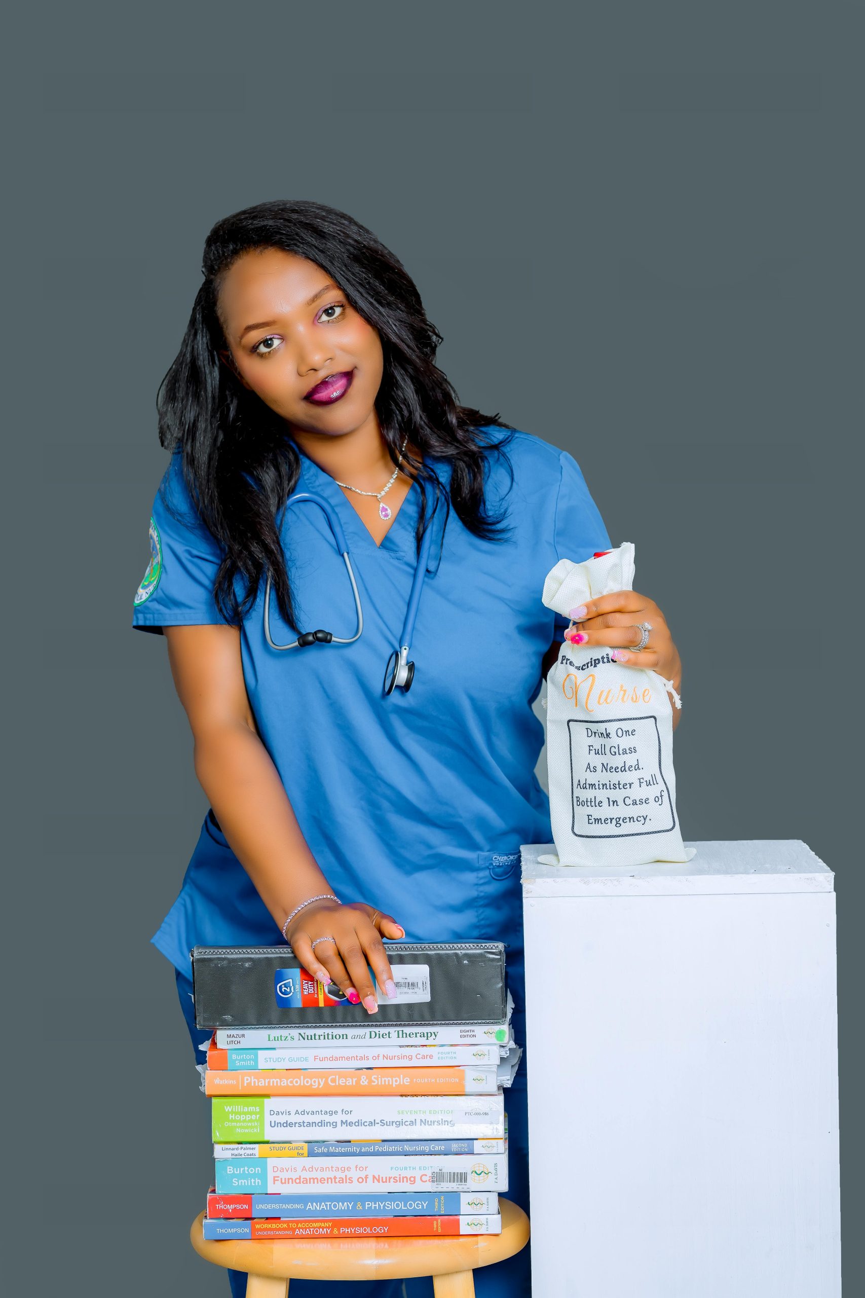 Healthcare professional with medical books and emergency supplies in studio setting.